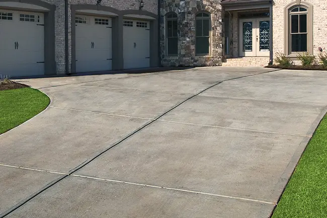 A dirty and stained residential concrete driveway before a professional pressure washing service service in Greenville, Wisconsin.